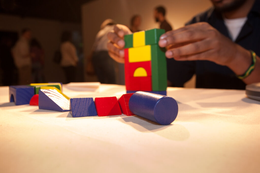 close up of hands building with multicolored blocks