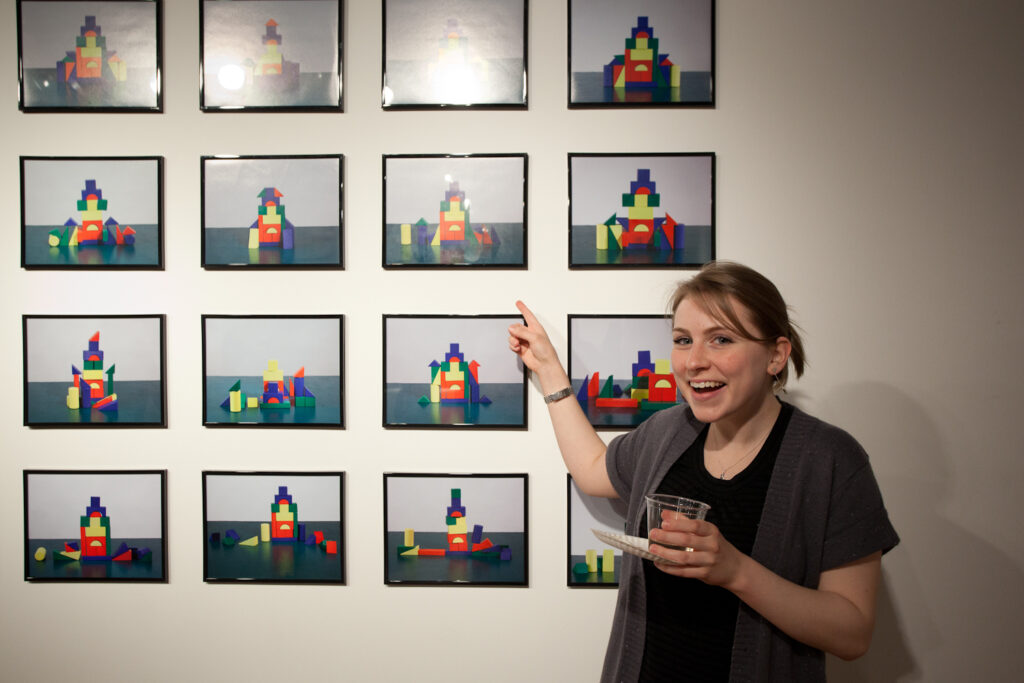 woman pointing to photographs on the wall