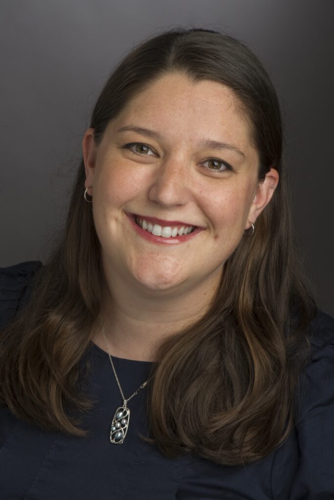 headshot of Artist, smiling woman with long brown hair