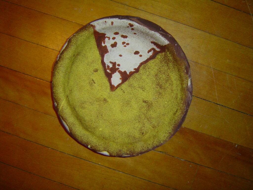 Photography on clay a pie plate made out of a photograph of a pie, with slice missing white plate, brown pie filling, yellow crust