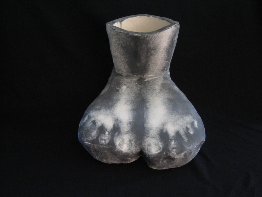 Feet, photograph on clay, gray scale , a vessel up to calf with two feet together