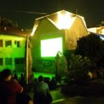 crowd in front of old building with projection on it