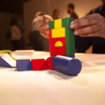 close up of hands building with multicolored blocks
