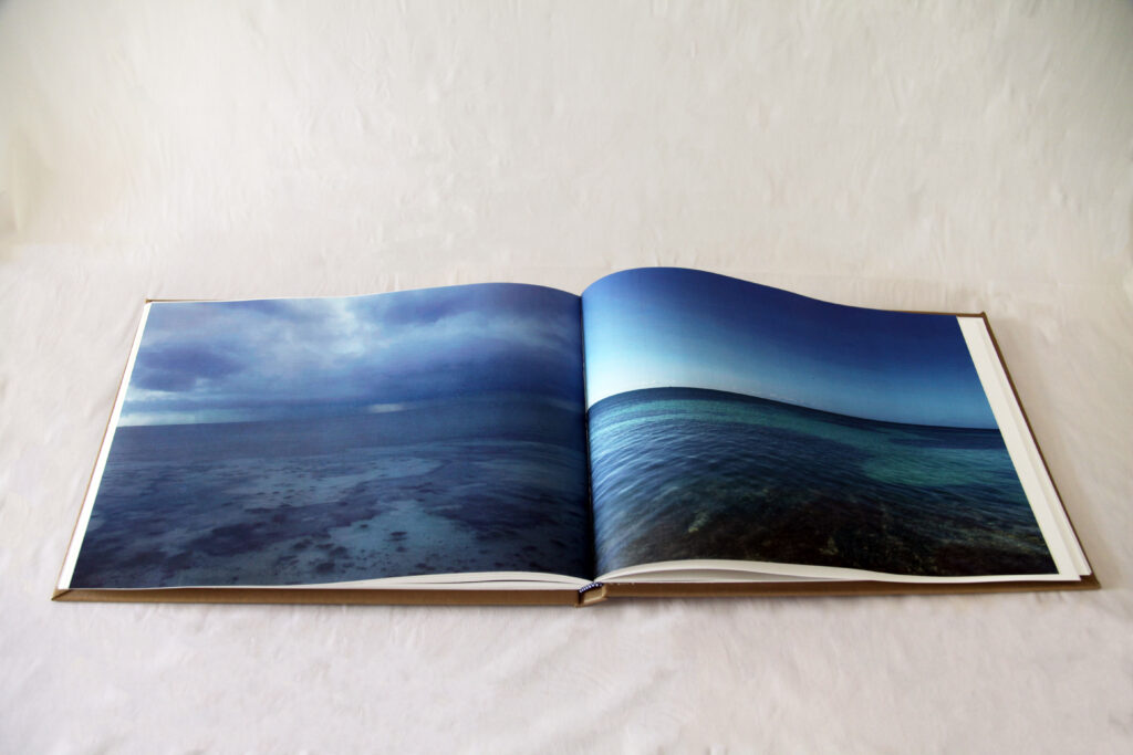 Open book with pictures of the ocean full bleeds